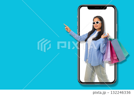 Young shopper showcases excitement while holding shopping bags 132246336