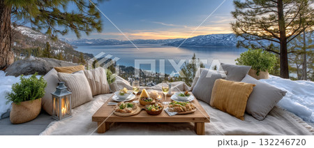 Cozy winter picnic with low table pillows lantern and lake view at sunset 132246720