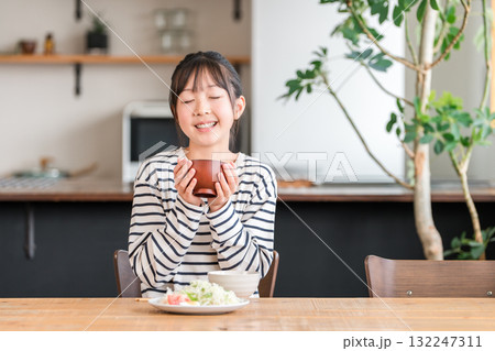 食卓・ダイニングテーブルで食事する小学生,中学生の女の子（ランチ,朝食,ご飯,食べる） 132247311