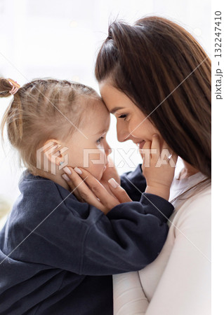 A tender moment between a mother and her young daughter, forehead to forehead, filled with love and affection. A tender moment between a mother and her young daughter, forehead to forehead, filled with love and affection. 132247410