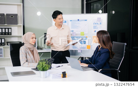 Group of young Asian business people discussing business plan at modern startup in creative business discussing work 132247654