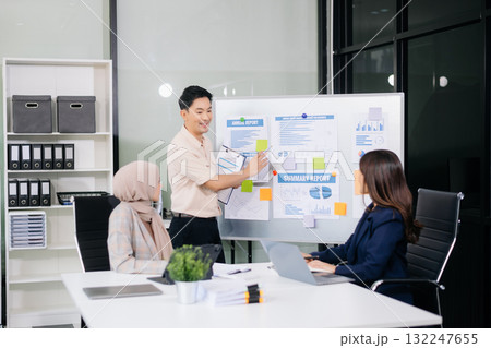 Group of young Asian business people discussing business plan at modern startup in creative business discussing work Group of young Asian business people discussing business plan at modern startup in creative business discussing work 132247655