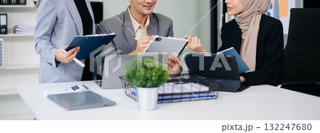 Group of young Asian business people discussing business plan at modern startup in creative business discussing work 132247680