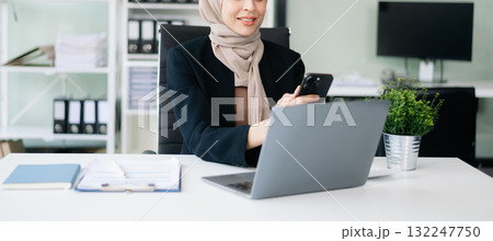 Young Muslim woman working with laptop and tablet Young Muslim woman working with laptop and tablet 132247750