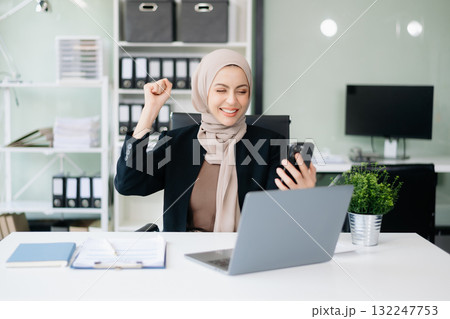Young Muslim woman working with laptop and tablet 132247753