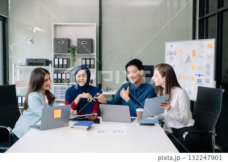 Happy businesspeople while collaborating on a new project in an office. Group of diverse businesspeople using a laptop and tablet 132247901
