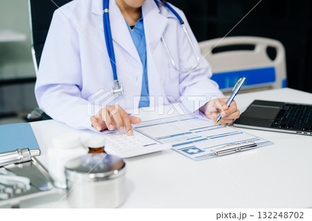 Healthcare costs and fees concept.Hand of smart doctor used a calculator and smartphone, tablet for medical costs Healthcare costs and fees concept.Hand of smart doctor used a calculator and smartphone, tablet for medical costs 132248702