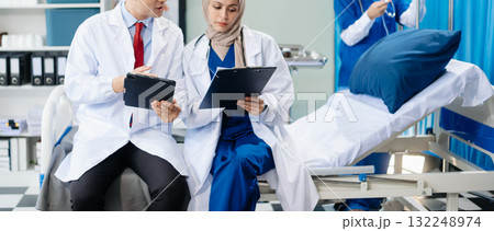 Medical professionals in modern hospital collaborating on patient care, research, and diagnosis. Doctors and nurses in hijabs discussing treatment plans, lab Medical professionals in modern hospital collaborating on patient care, research, and diagnosis. Doctors and nurses in hijabs discussing treatment plans, lab 132248974