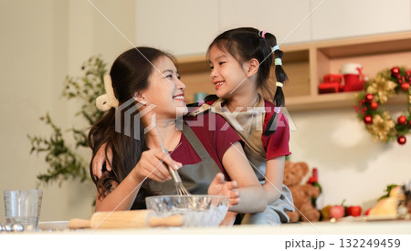 Family Cooking Happy mother and daughter enjoying baking together in a festive kitchen. Family Cooking Happy mother and daughter enjoying baking together in a festive kitchen. 132249459