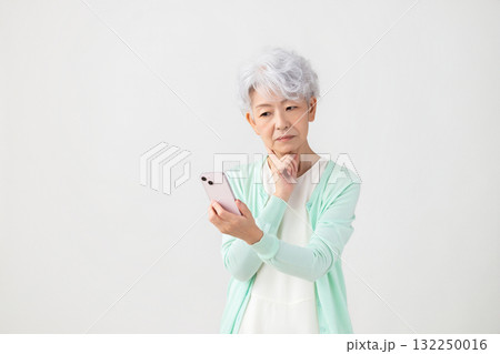 スマホを見ているシニア女性 132250016