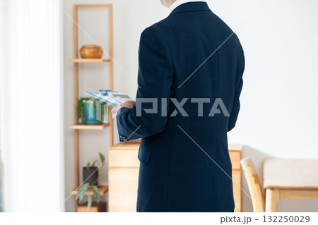 家具のチェックをするスーツ姿の男性 132250029