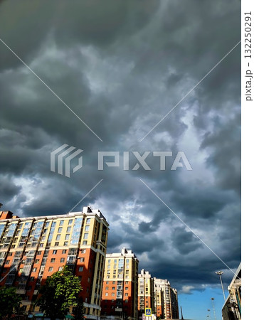 Modern residential buildings in Saint Petersburg are dramatically framed by dark, heavy storm clouds gathering overhead on a threatening day. Modern residential buildings in Saint Petersburg are dramatically framed by dark, heavy storm clouds gathering overhead on a threatening day. 132250291