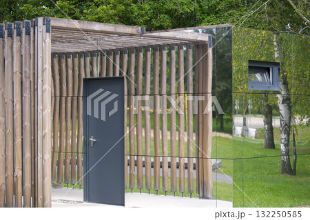 Modern architectural structure with wooden elements and reflective surfaces. 132250585