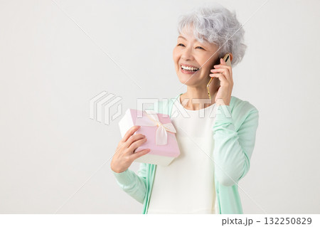 スマホ　プレゼントをもらって喜ぶシニア女性　 132250829