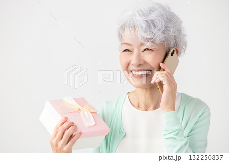 スマホ　プレゼントをもらって喜ぶシニア女性　 132250837