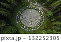 Exploring a circular stone labyrinth surrounded by green forest landscape in the early morning light 132252305