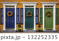 Colorful doors with wreaths decorate a vibrant brick wall in a charming neighborhood  132252335
