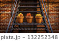 Colorful potted plants on a metal staircase against a brick wall in a cozy urban setting  132252348