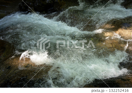 岩に当たっている川の流れ 132252416