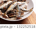 Baked sardines in a white ceramic bowl on the kitchen table 132252518