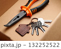 Cardboard box with a bunch of door keys and construction tool close up 132252522