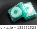 Dental floss on a black surface. Oral hygiene products close up 132252528