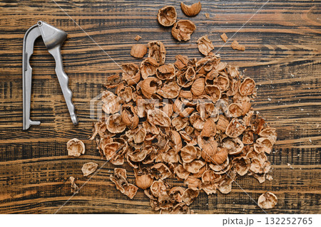 Nut shells and a nutcracker scattered on a wooden surface after a snack time 132252765