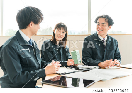 ビルの模型を見ながら会議,ミーティングする作業着姿の男女のビジネスマン 132253036