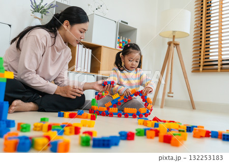 happy toddler girl and mother playing building blocks or plastic bricks toy at home happy toddler girl and mother playing building blocks or plastic bricks toy at home 132253183