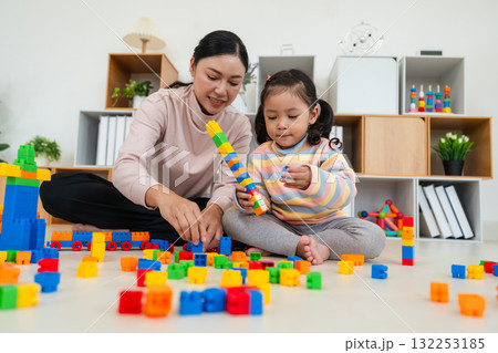 happy toddler girl and mother playing building blocks or plastic bricks toy at home happy toddler girl and mother playing building blocks or plastic bricks toy at home 132253185