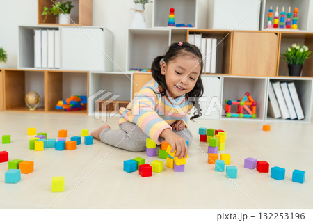 toddler girl playing block toy to stacks building cubes at home toddler girl playing block toy to stacks building cubes at home 132253196