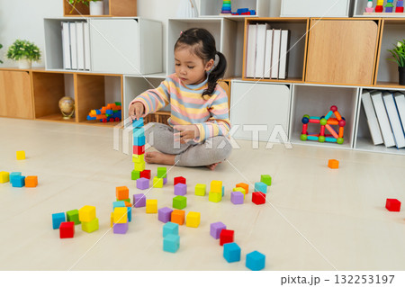 toddler girl playing block toy to stacks building cubes at home 132253197