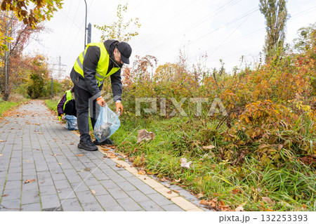 People Picking Up Trash Outdoors People Picking Up Trash Outdoors 132253393