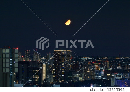 Early half harvest moon in Tokyo over the new Takanawa Gateway Marriott Hotel in the early evening in Minato-ku Tokyo Japan Early half harvest moon in Tokyo over the new Takanawa Gateway Marriott Hotel in the early evening in Minato-ku Tokyo Japan 132253434