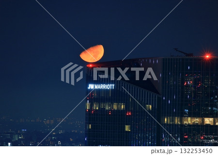 Early half harvest moon in Tokyo over the new Takanawa Gateway Marriott Hotel in the early evening in Minato-ku Tokyo Japan Early half harvest moon in Tokyo over the new Takanawa Gateway Marriott Hotel in the early evening in Minato-ku Tokyo Japan 132253450