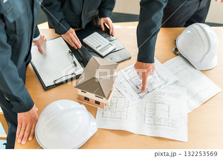 住宅模型,設計図の前で会議,ミーティングをするビジネスマン 132253569