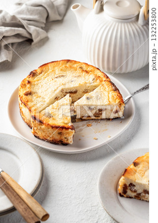 Homemade cottage cheese casserole pie with raisins. Baked cheesecake for healthy breakfast on white table background 132253800