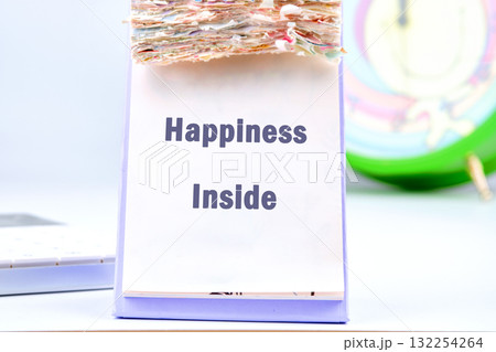 A colorful calendar sits on a desk, with the words happiness inside prominently featured. Soft light enhances the joyful ambiance, encouraging a positive mindset throughout the day A colorful calendar sits on a desk, with the words happiness inside prominently featured. Soft light enhances the joyful ambiance, encouraging a positive mindset throughout the day 132254264