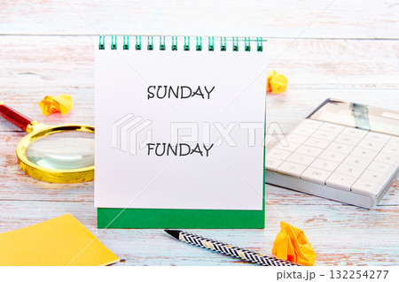 A cheerful setup featuring a notebook with SUNDAY FUNDAY written on it, surrounded by a magnifying glass, calculator, and crumpled paper, perfect for planning fun activities A cheerful setup featuring a notebook with SUNDAY FUNDAY written on it, surrounded by a magnifying glass, calculator, and crumpled paper, perfect for planning fun activities 132254277