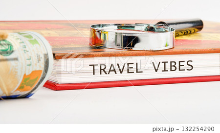 Taking in travel vibes with a guidebook, magnifying glass, and money. Planning unforgettable adventures inspires a journey of discovery and exploration ahead 132254290