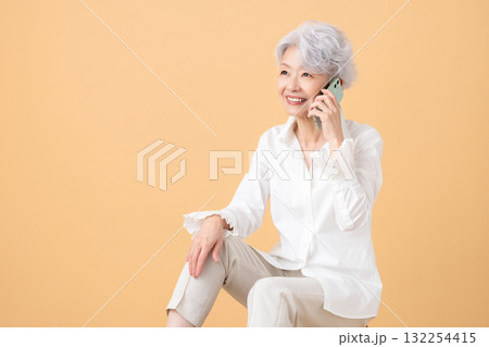 シニア女性 スマホで電話をしているシニア女性 シニア女性 スマホで電話をしているシニア女性 132254415