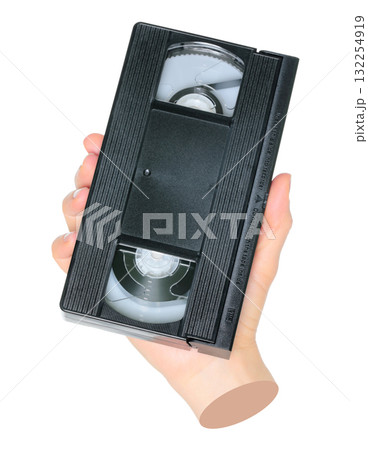 Woman hand holds a retro old analog video cassette, isolated on transparent background, retro things concept. Contemporary art 132254919