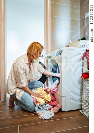Laundry day routine featuring a woman in casual attire Laundry day routine featuring a woman in casual attire 132255015