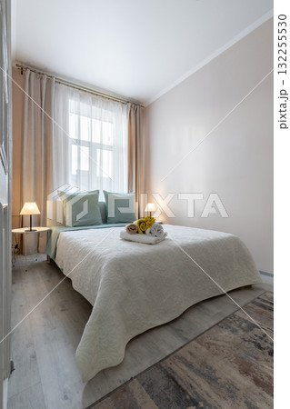 Bright Cozy Bedroom with Soft Lighting and Fresh Towels Bright Cozy Bedroom with Soft Lighting and Fresh Towels 132255530
