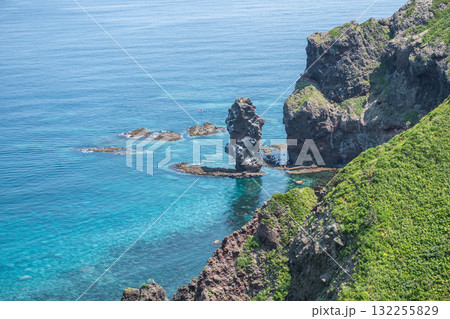 Rock formation and clear blue sea along green coastal cliffs at Cape Kamui, Kozakicho, Hokkaido, Japan 132255829
