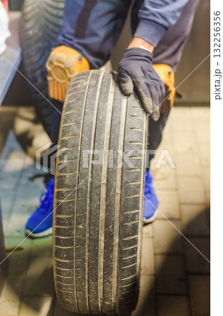 Mechanic Holding Used Car Tire Auto Maintenance Concept Mechanic Holding Used Car Tire Auto Maintenance Concept 132256356