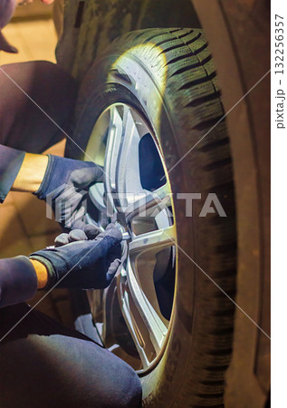 Mechanic Tightening Wheel Bolts with Wrench Car Tire Change 132256357