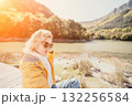 Woman Sunglasses River Hiking - Blond woman wearing sunglasses looks at the camera while enjoying a scenic hike next to a river. 132256584