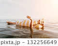Woman Float Relaxing Beach Ocean Summer - A woman in a striped inflatable float is relaxing in the ocean on a sunny day. 132256649