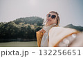 Smiling Woman in Sunglasses Taking a Selfie in Nature 132256651